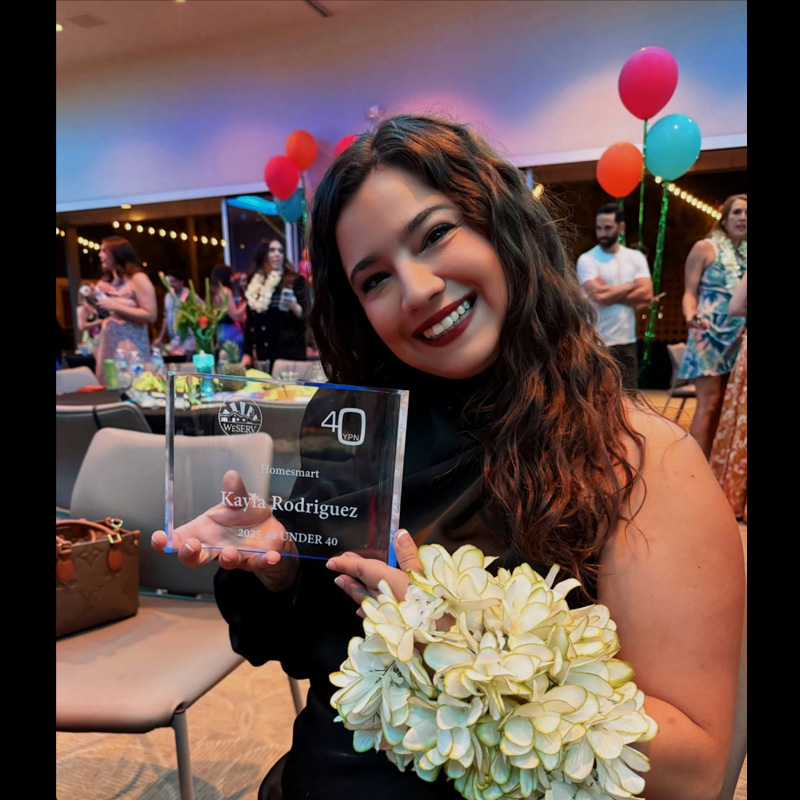 Kayla Rodriguez, Realtor, holding her 2025 WeSERV 40 Under 40 award.
